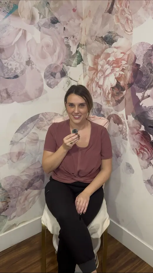Marley seated in front of a floral wall