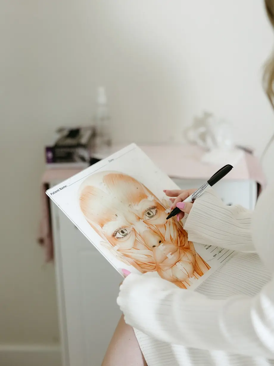 Injector marking a face chart while planning a treatment