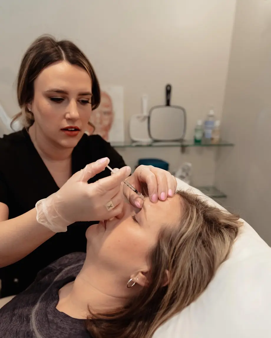 Injector treating a client lying on the treatment chair