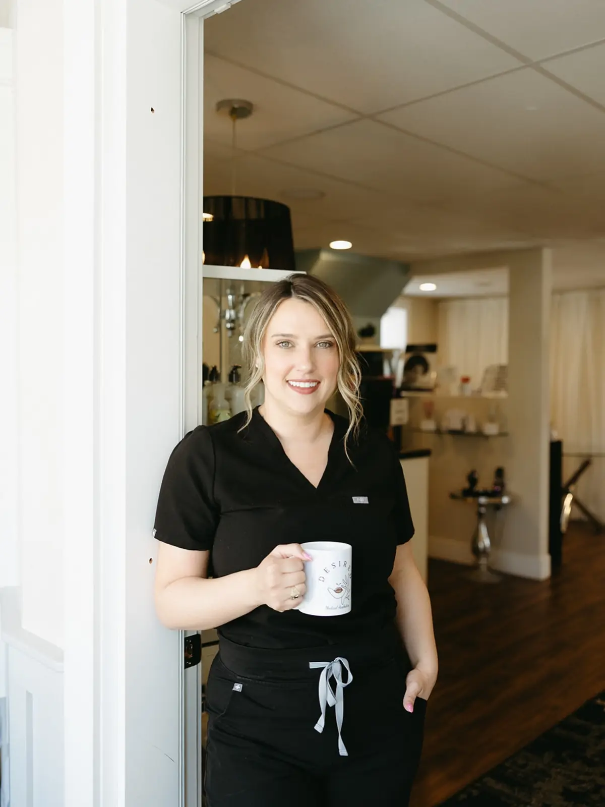 Marley at the clinic door holding a coffee mug