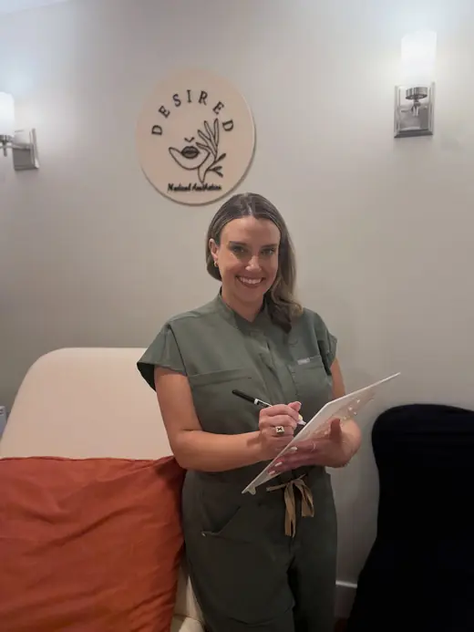 Marley in green scrubs with a clipboard beside the Desired sign