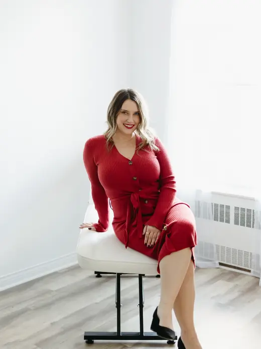 Marley in a red dress seated in a bright room